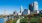 a park with a river and tall buildings in the background